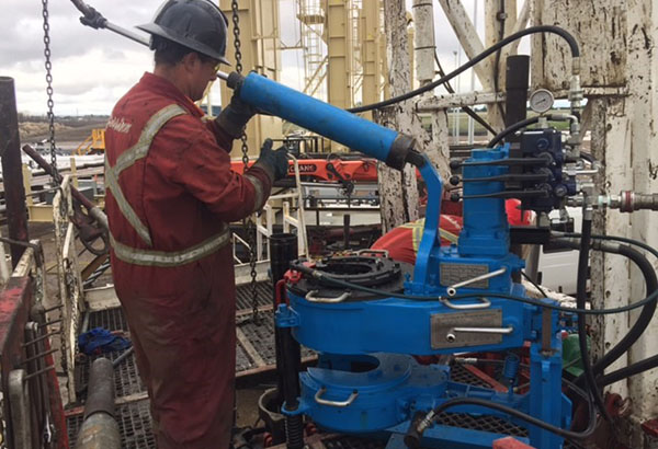 Monsoon Oilfield worker operating power tongs